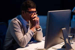 Stressed overworked Indian businessman looking at the computer screen